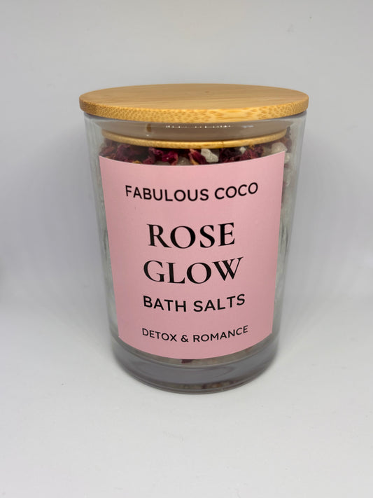 Rose Glow Bath Salts in a clear jar with bamboo lid and pink label.