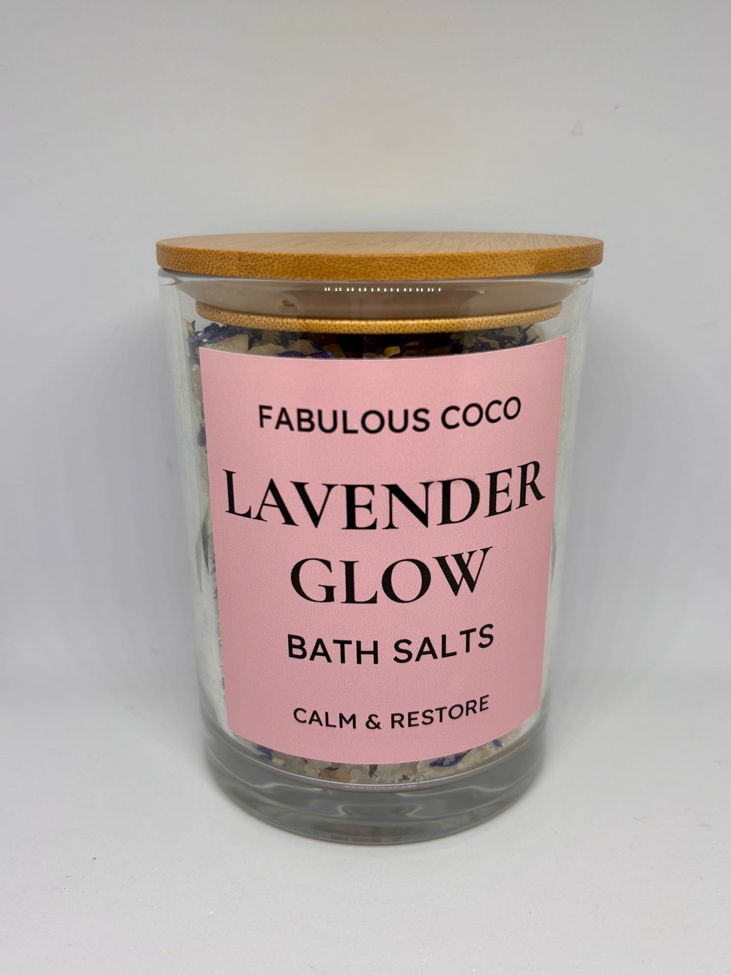Lavender Glow Bath Salts in a clear jar with bamboo lid and pink label.